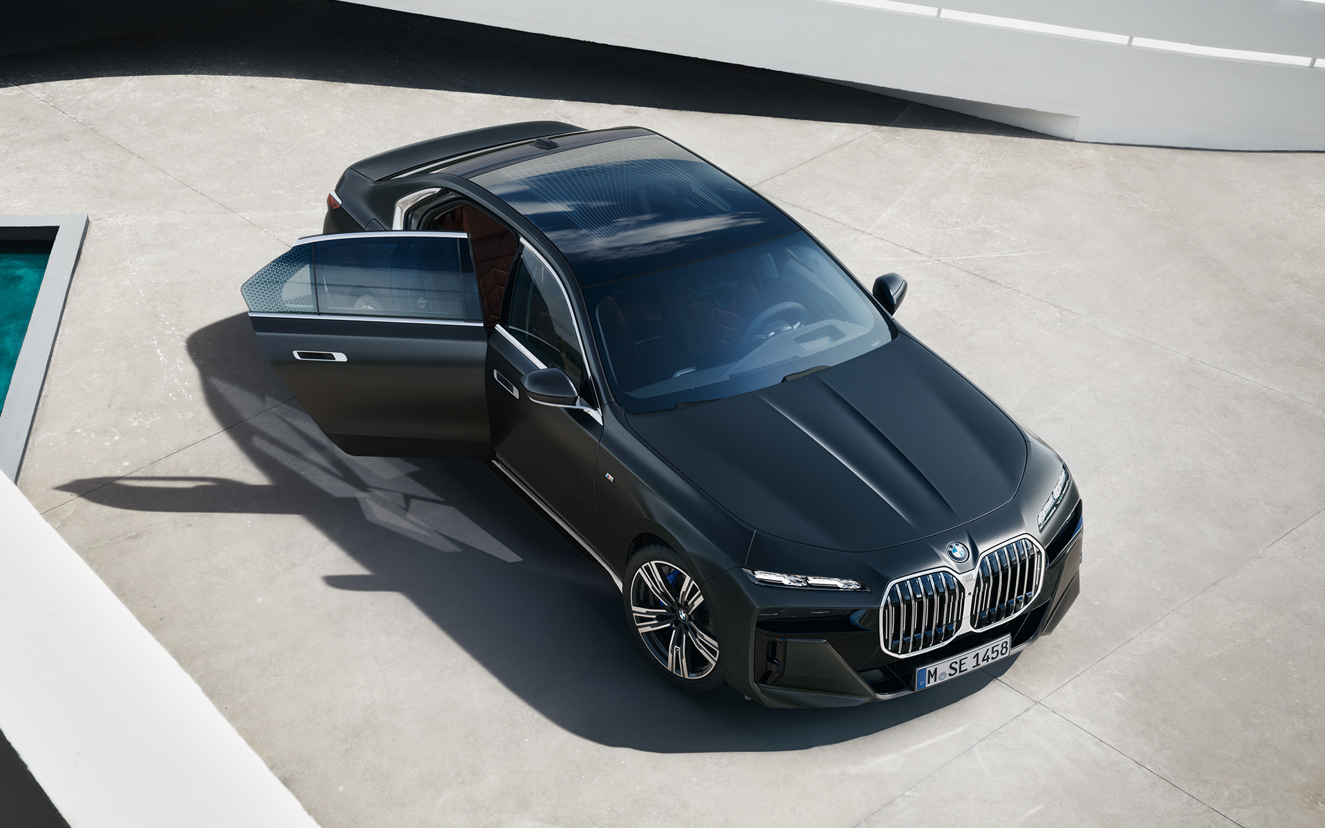 BMW Серия 7 G70 ICE 740i M спортен пакет Frozen Deep grey metallic от перспектива птичи поглед с отворена задна врата